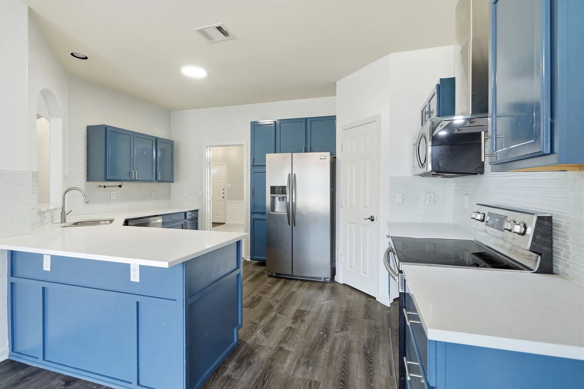 Updated kitchen with blue cabinetry and quartz countertops