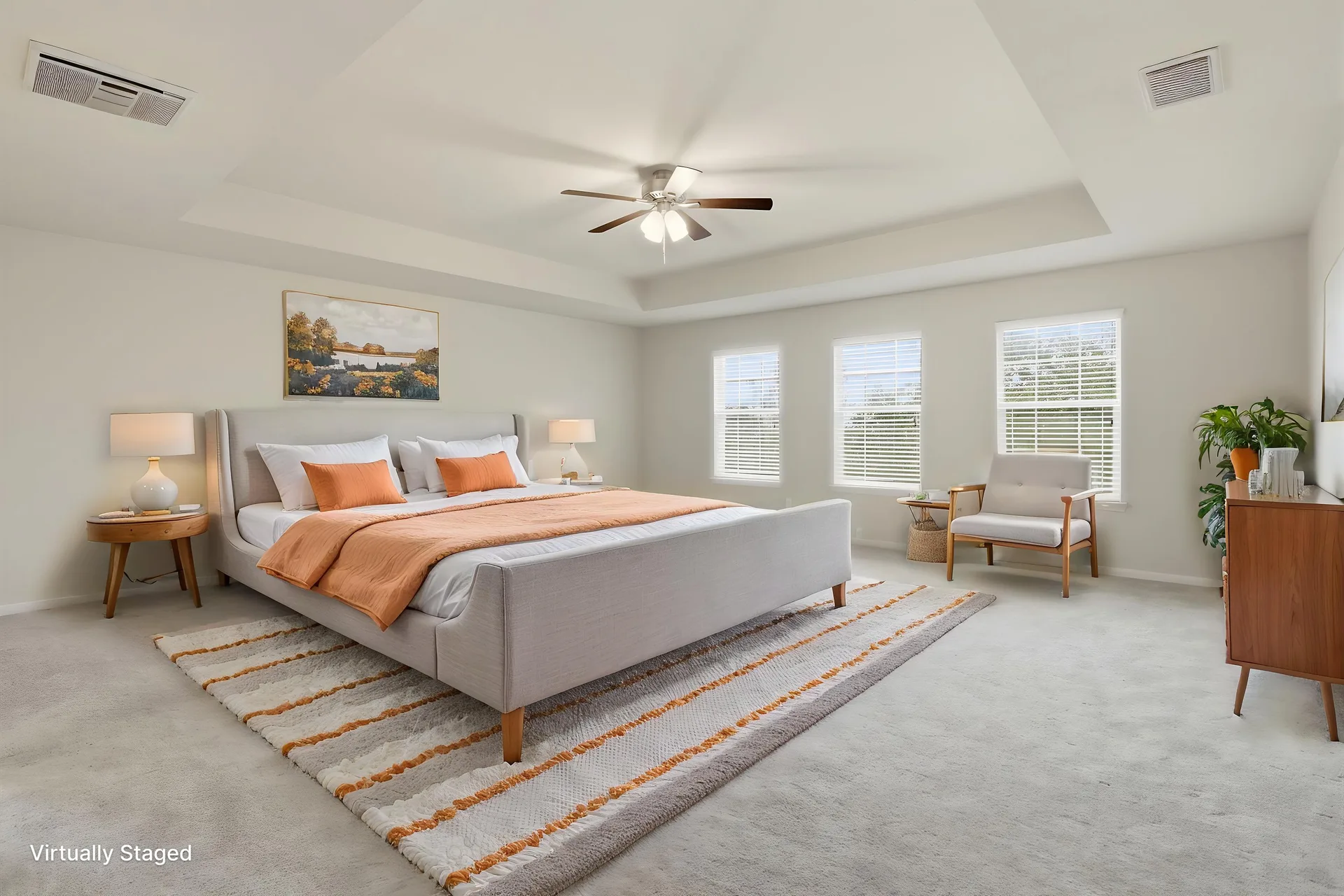 Primary bedroom with tray ceiling, styled