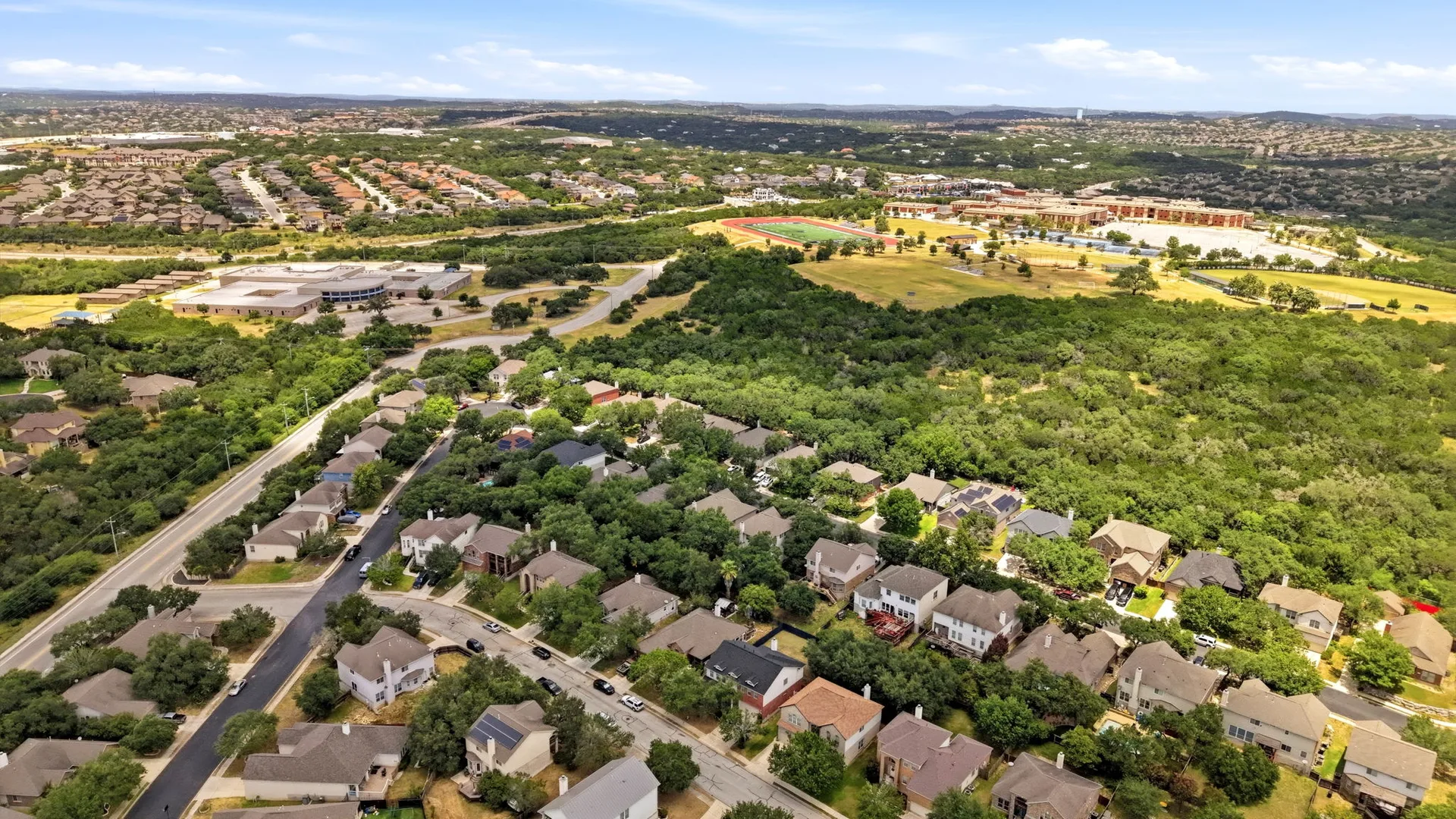 Aerial view of the Pinon Creek neighborhood showing 123 Impala Cir with the school visible in the background