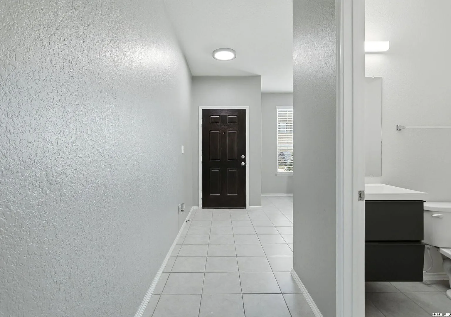 Entry hallway with ceramic tile flooring and a view toward the front door.