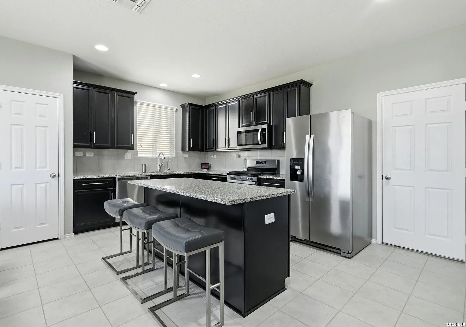 Kitchen with dark wood cabinets, granite countertops, and a breakfast island.