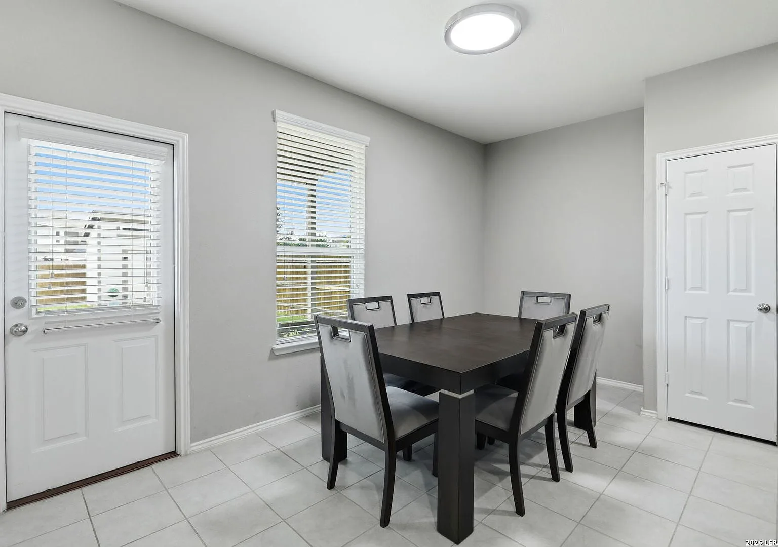 Casual dining space with an exterior door, white trim, and tile flooring.