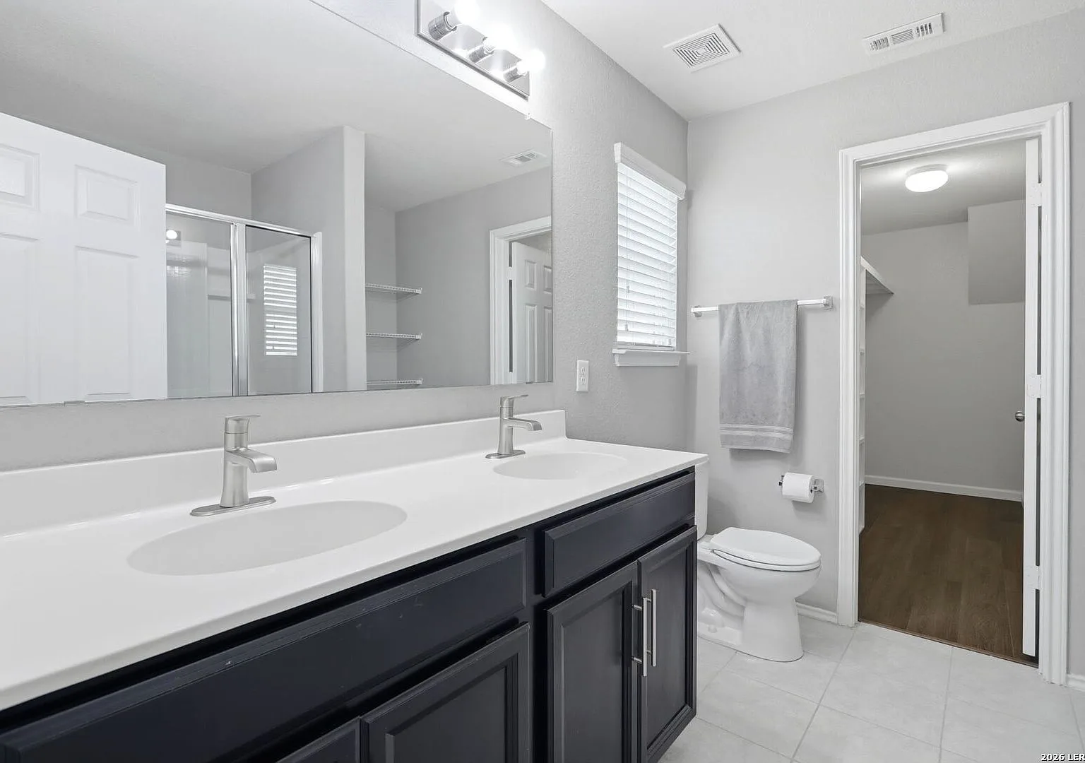 Primary ensuite bath with dual undermount sinks and a dark wood vanity.