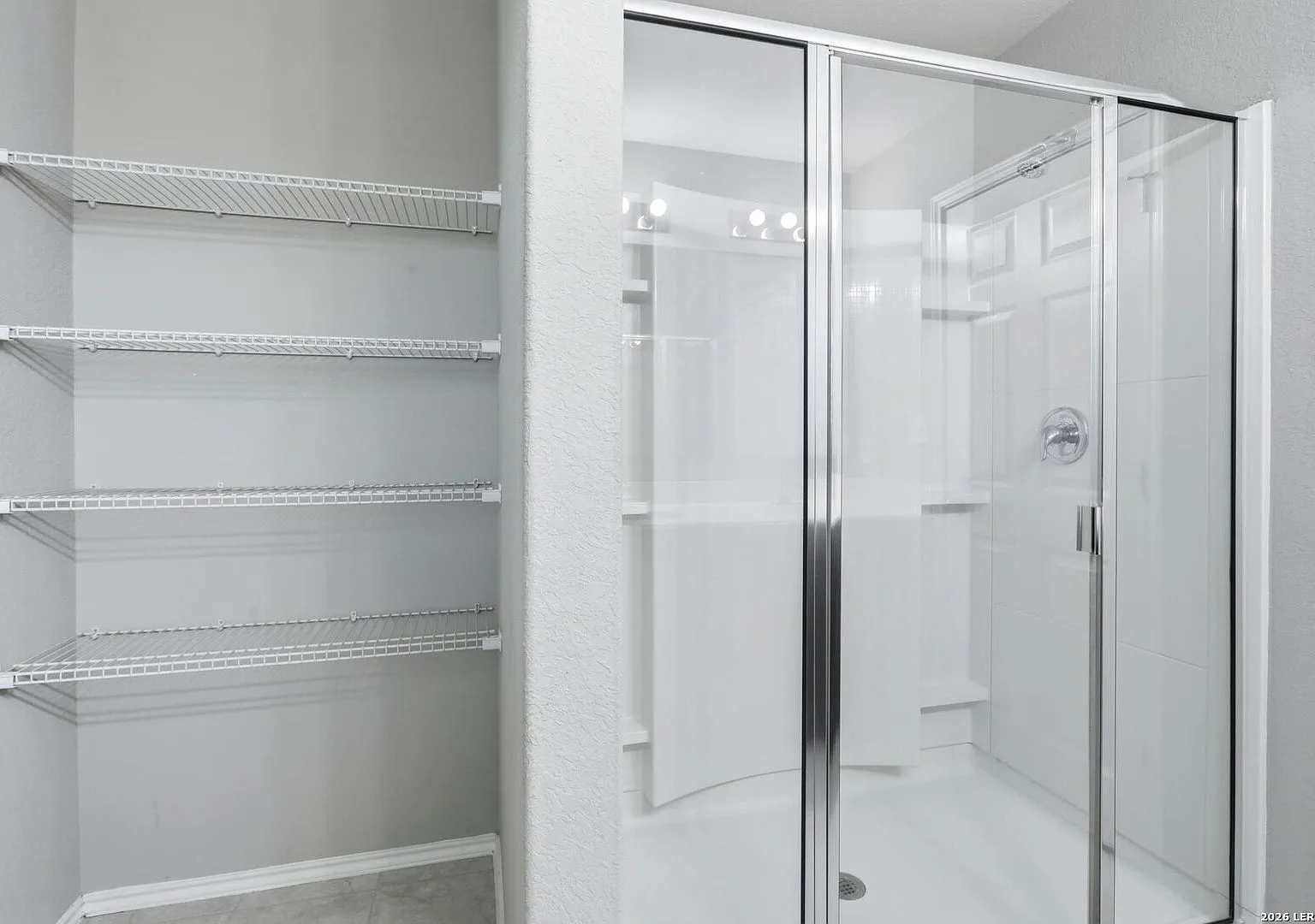 Primary bath walk-in shower with a glass-and-metal sliding door.