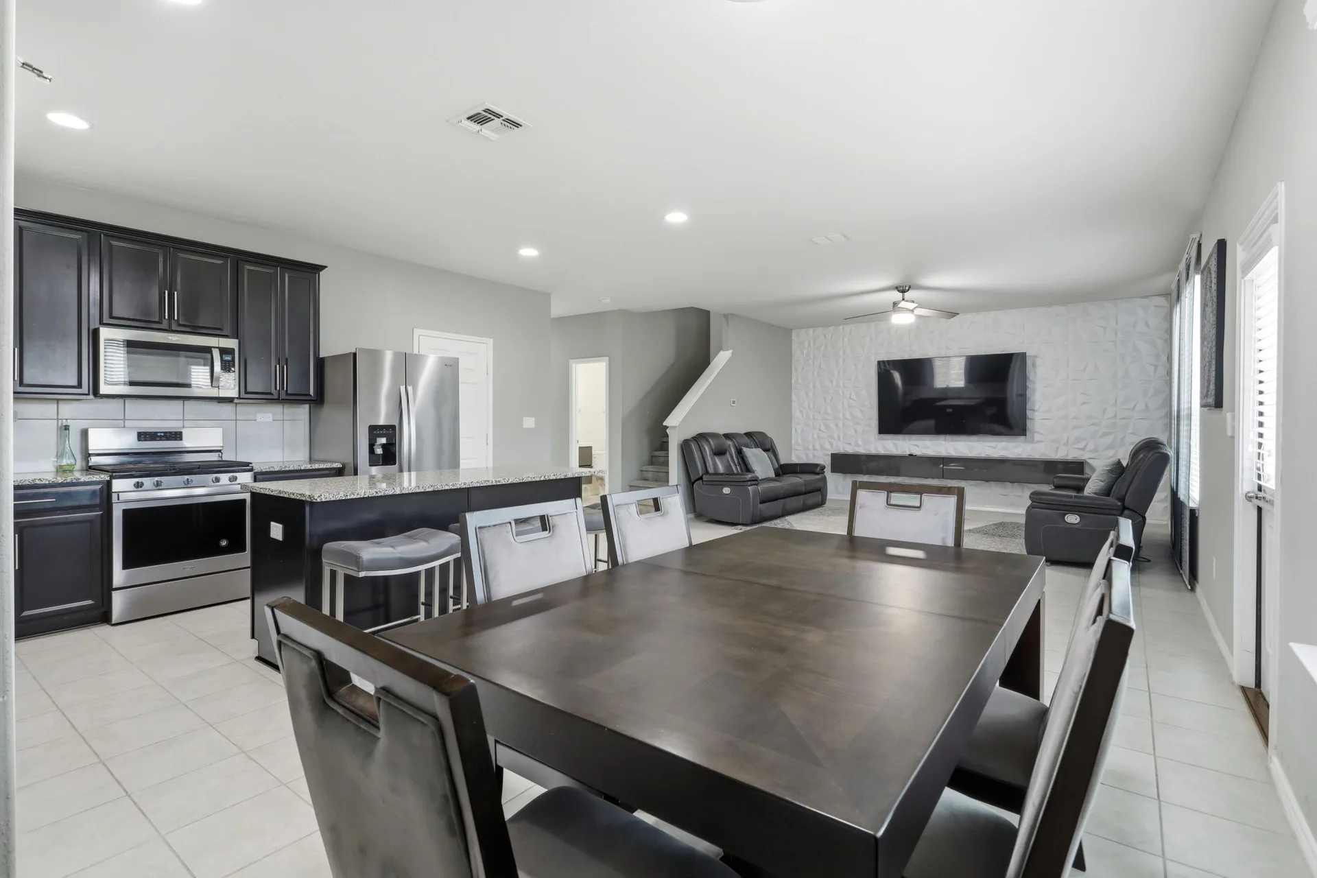 Open kitchen and dining area with a breakfast island and barstools.