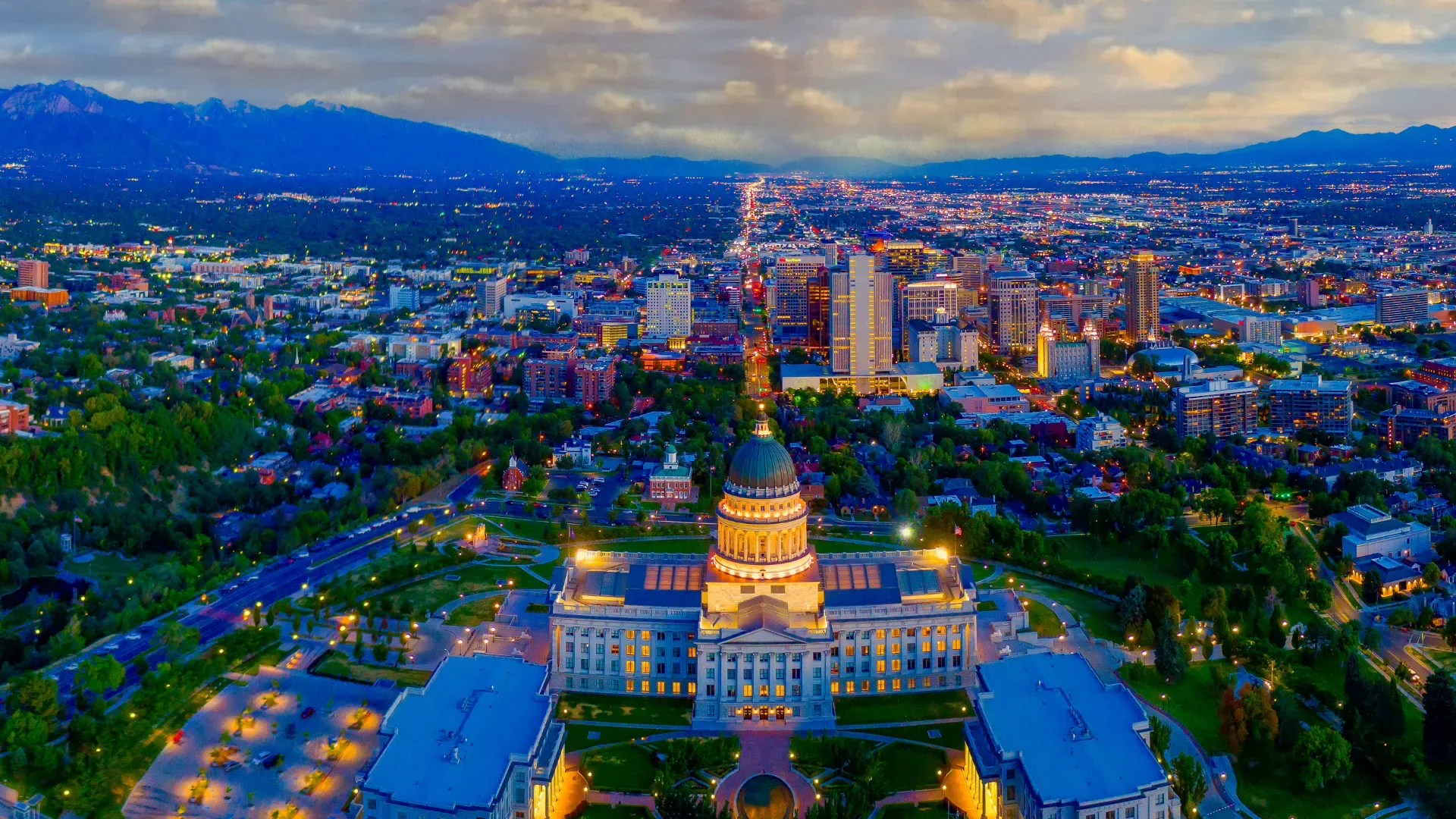 The Utah State Capitol and Salt Lake City at twilight, with the Wasatch Front mountains rising beyond
