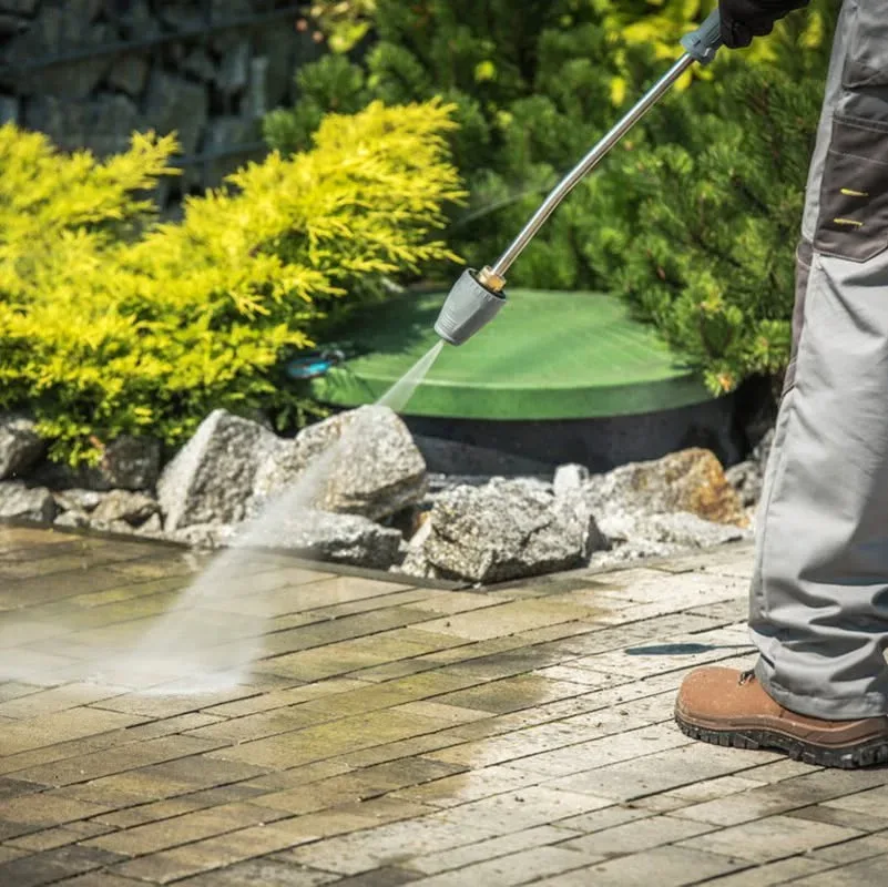 A pressure washing job in San Antonio: cleaning a gray paver walkway with a pressure washer, bringing the stone back to a fresh, even color