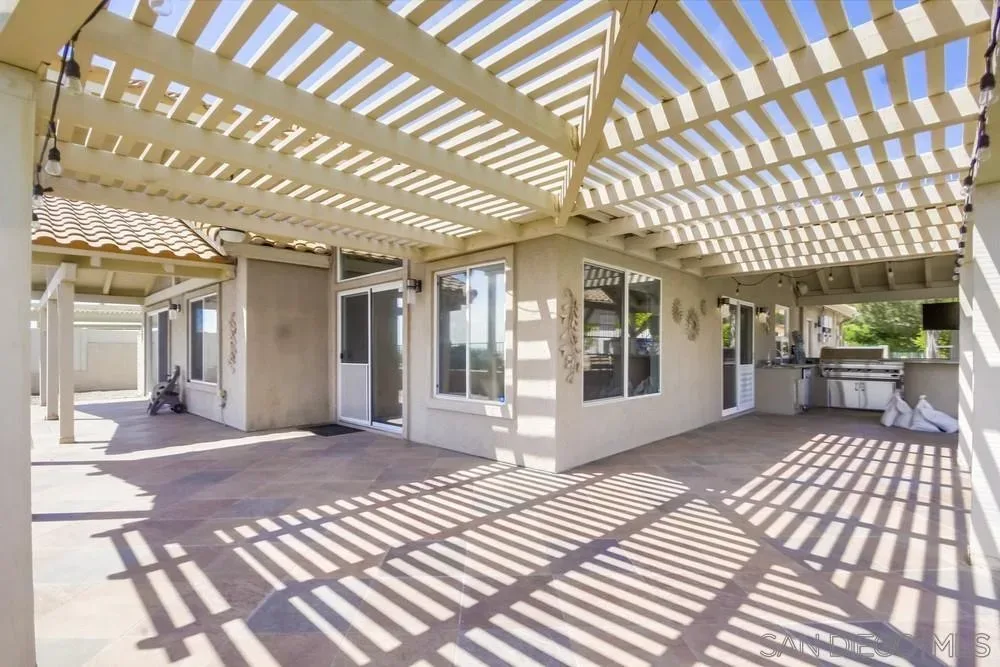 Covered backyard patio with pergola at the Crown Hills home