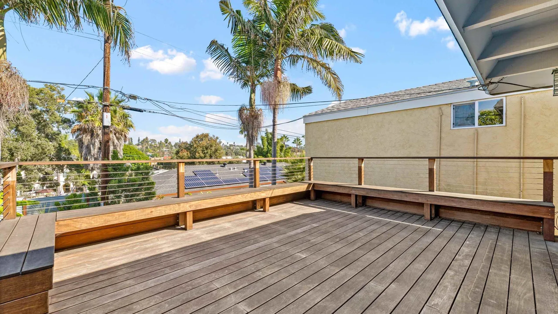 Rooftop deck with built-in bench seating and cable railings at 425 Neptune Ave