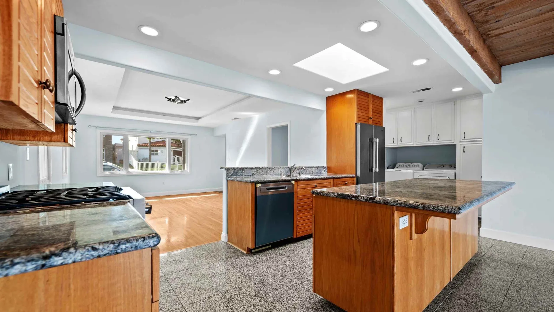 Kitchen with wood cabinets and an island flowing into the living space