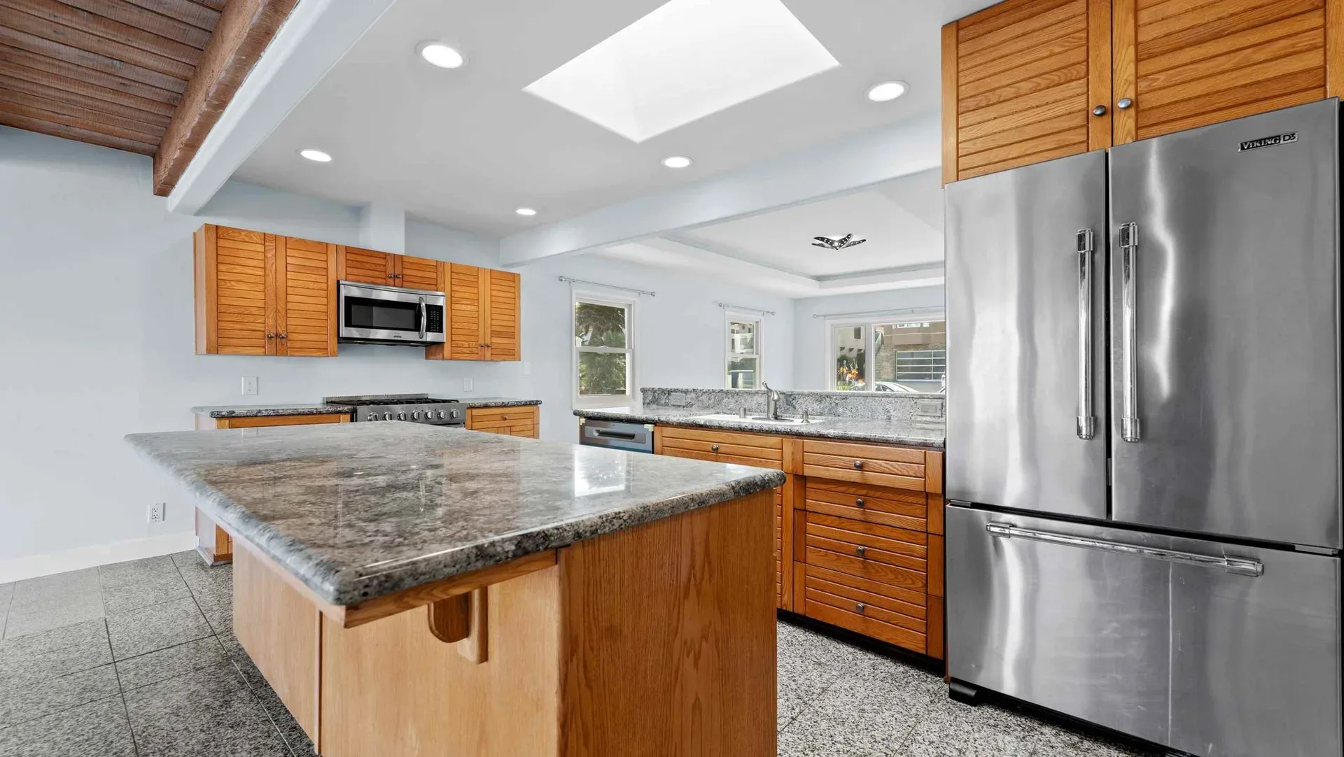 Kitchen with slatted wood cabinetry and a skylight at the Encinitas bungalow