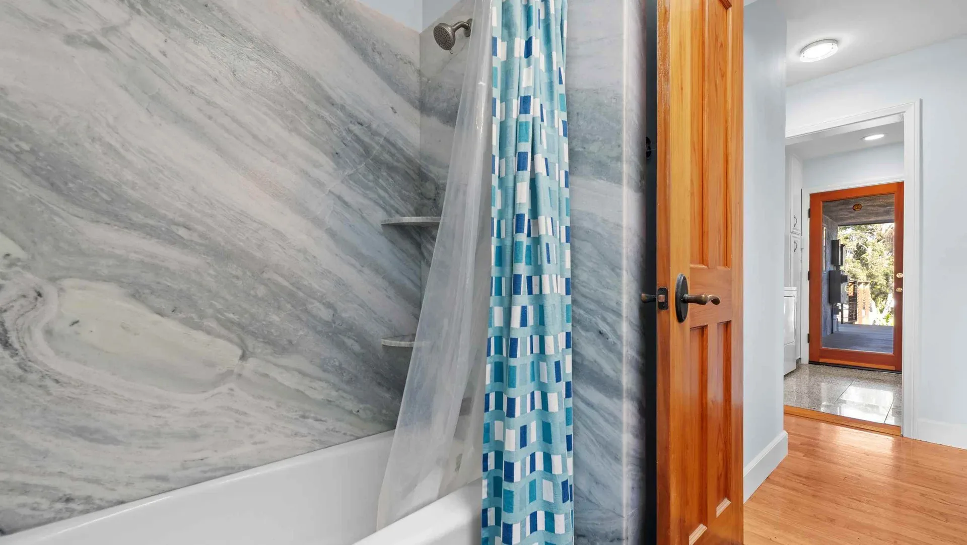 Bathroom with marble-patterned tile shower at the beach bungalow