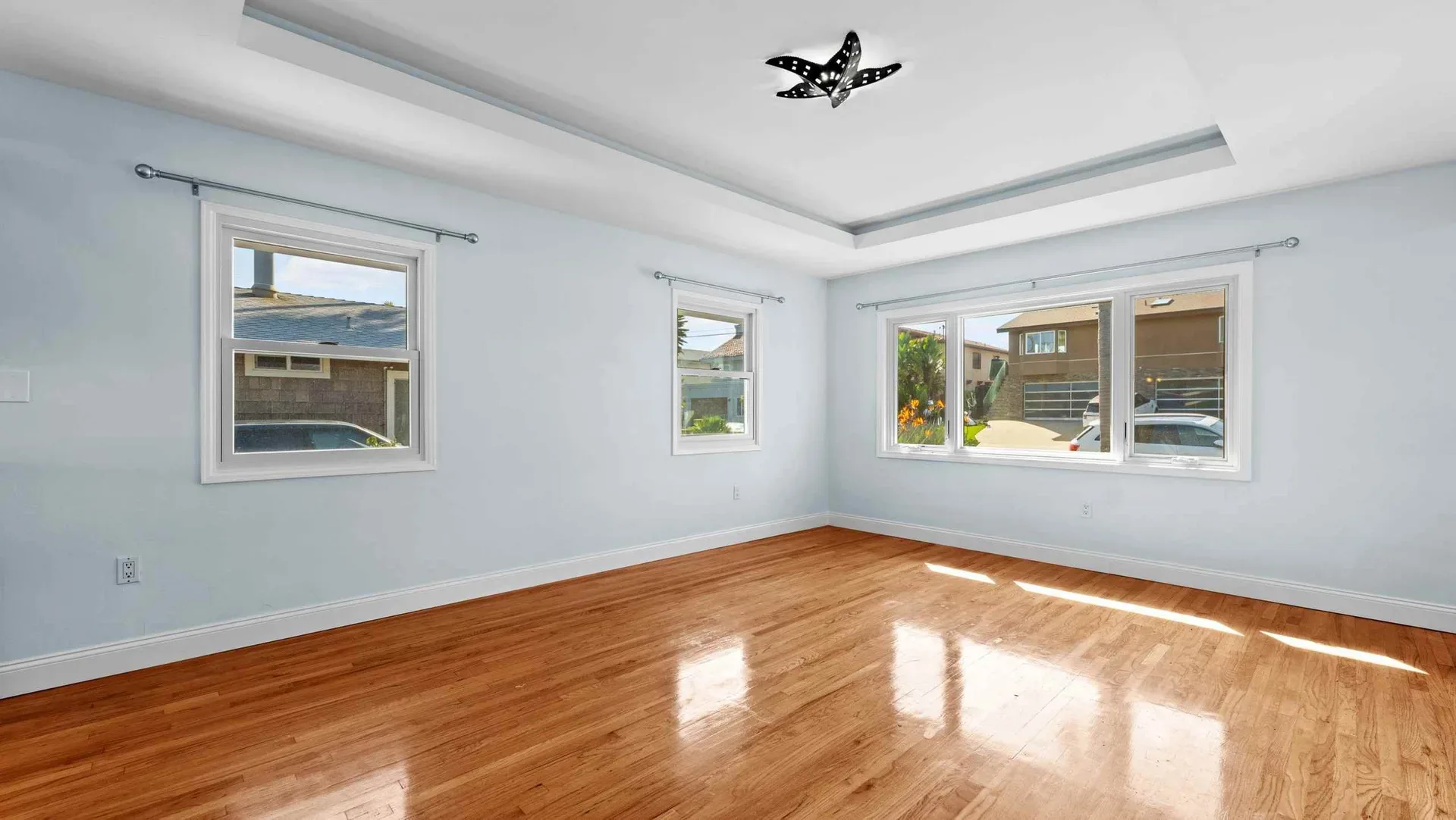 Master bedroom with a tray ceiling and hardwood floors at 425 Neptune Ave