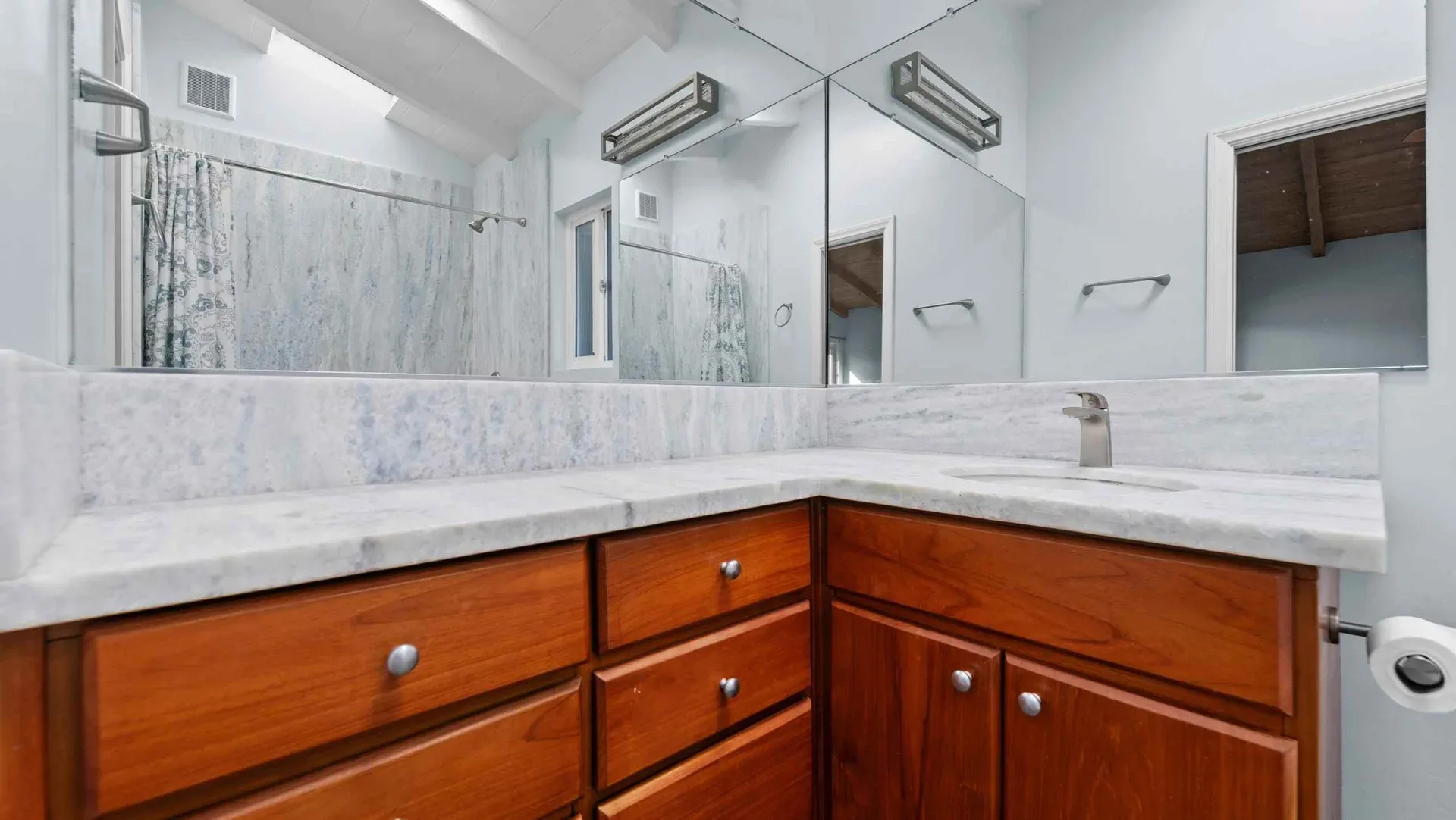 Bathroom with a wood vanity and marble countertop at the beach bungalow