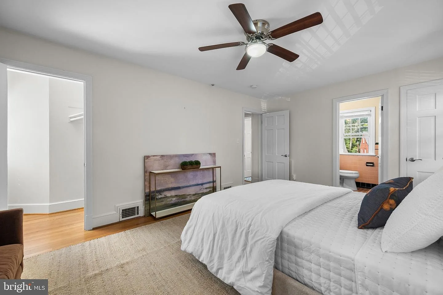 Primary bedroom with hardwood flooring and bright natural light