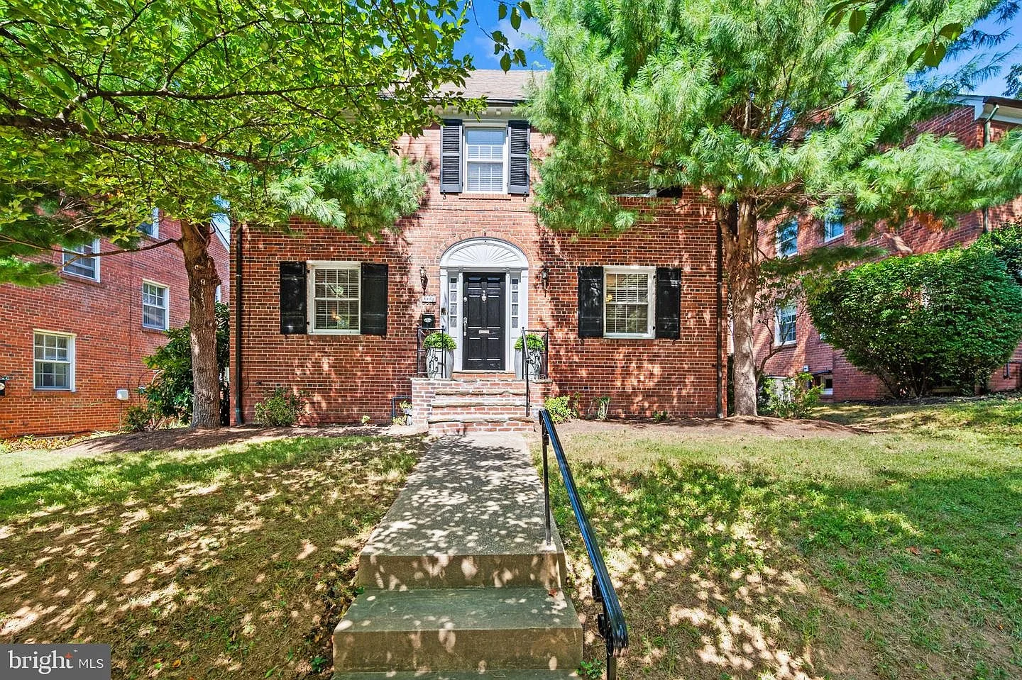 Front entry of the brick Colonial with white arched door frame