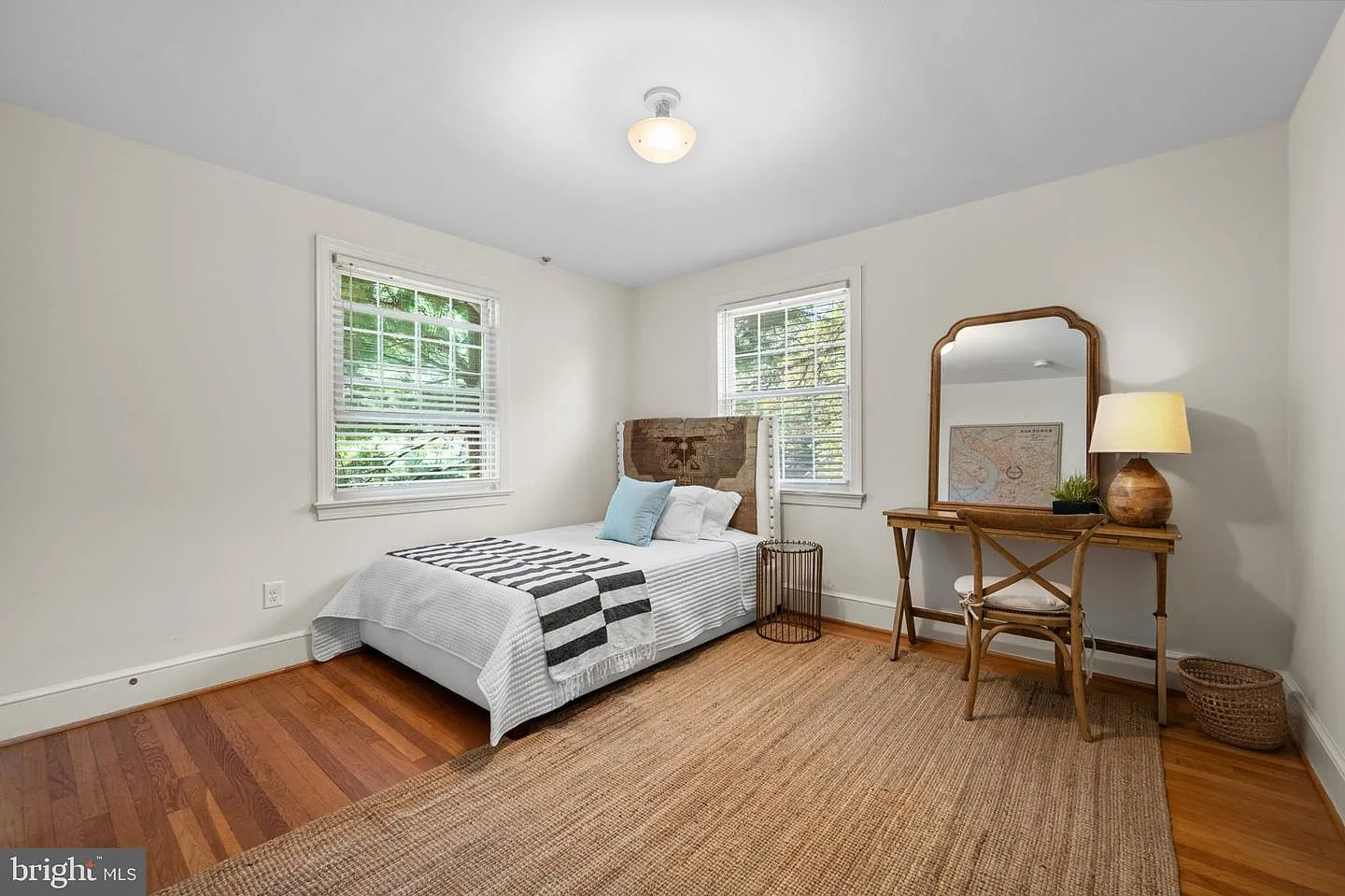Spare bedroom with hardwood flooring and two windows
