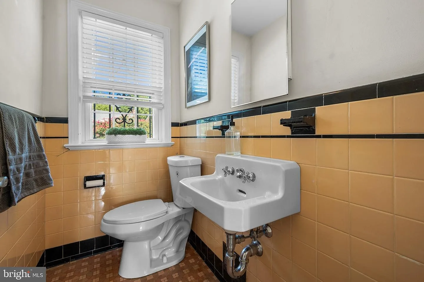 Bathroom with vintage yellow and black tile wainscoting