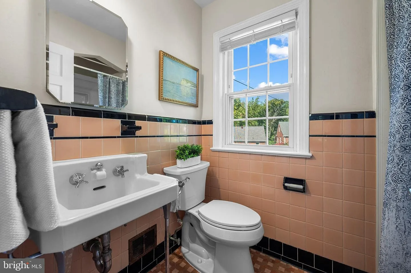 Vintage 1940s pink tiled bathroom with black accent trim