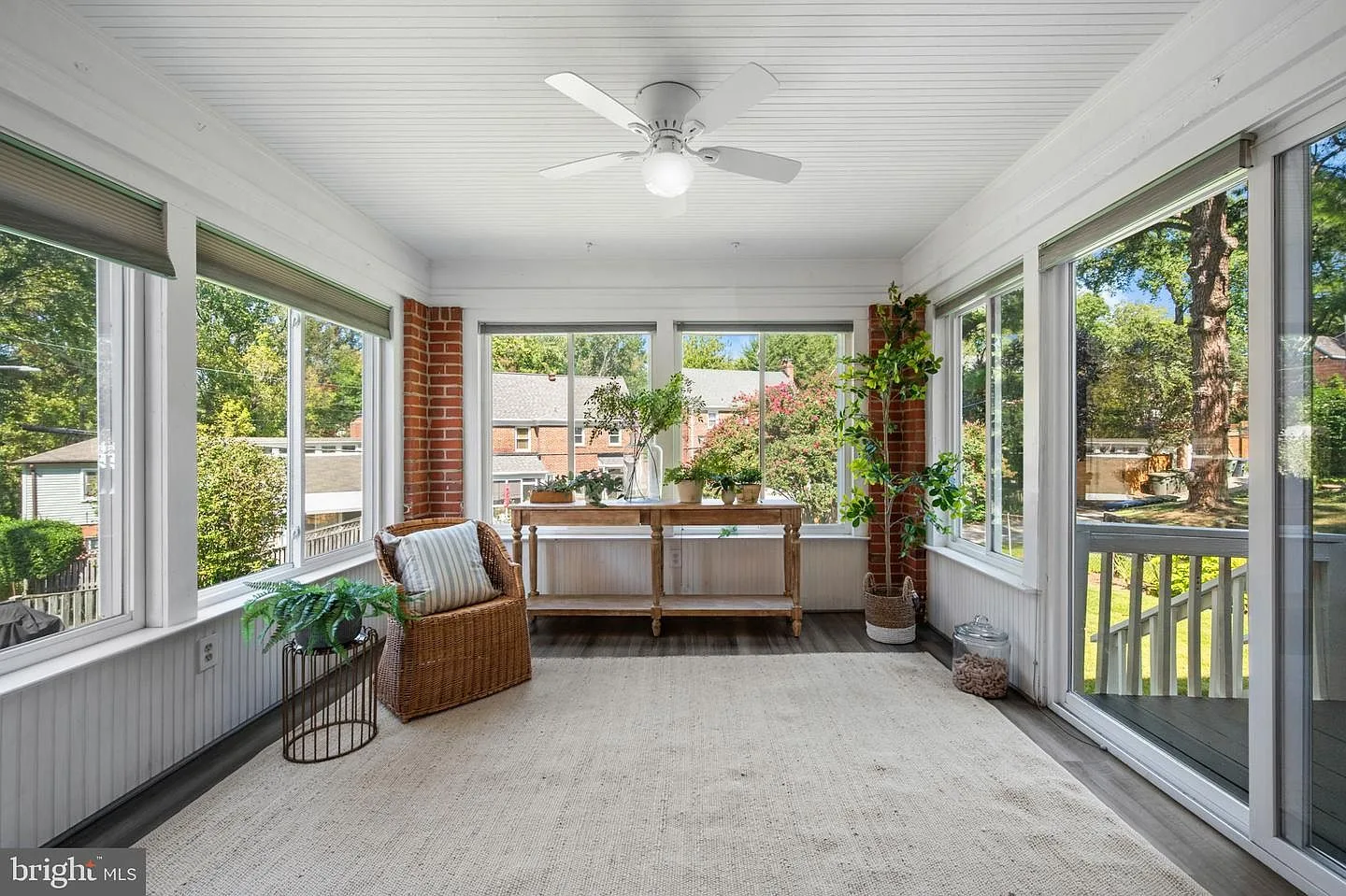 Enclosed porch with exposed brick accents and beadboard ceiling