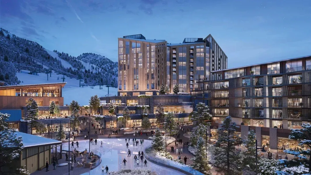 Deer Valley's alpine terrain with a new mountain village glowing beneath the slopes at dusk