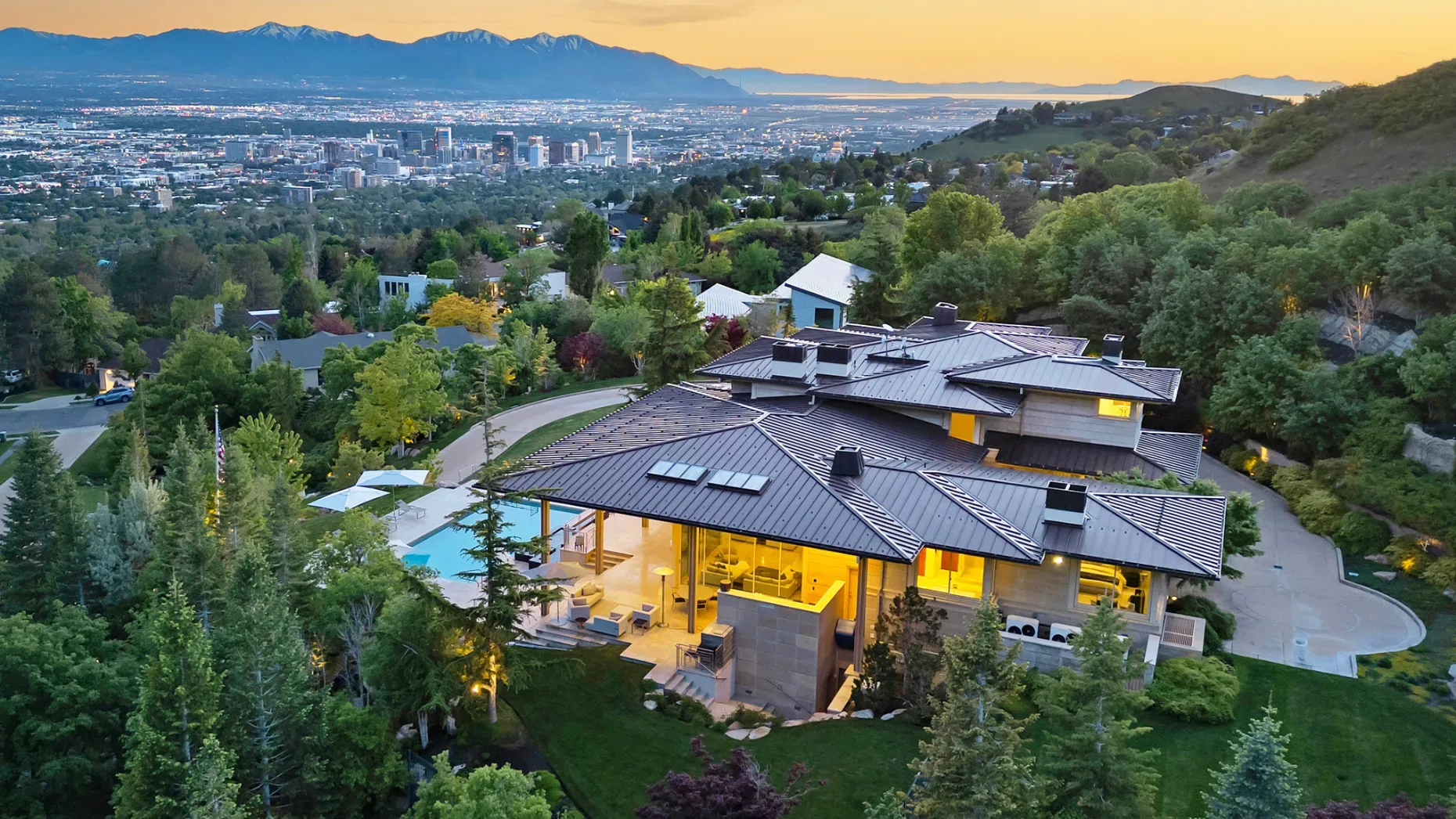A twilight aerial of a luxury estate above Federal Heights with the city behind it