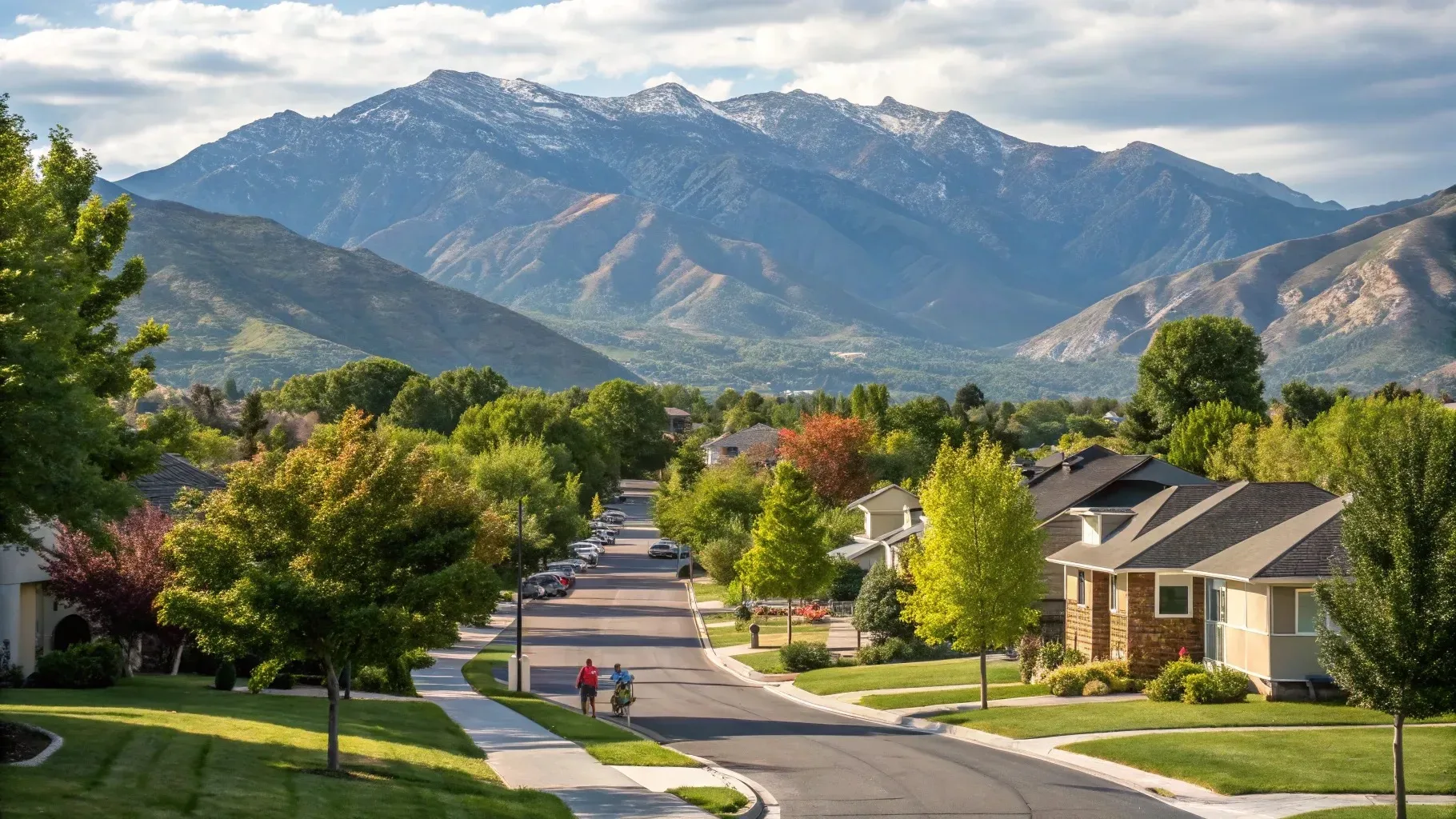 A Millcreek residential street with the Wasatch range rising behind it on a clear day