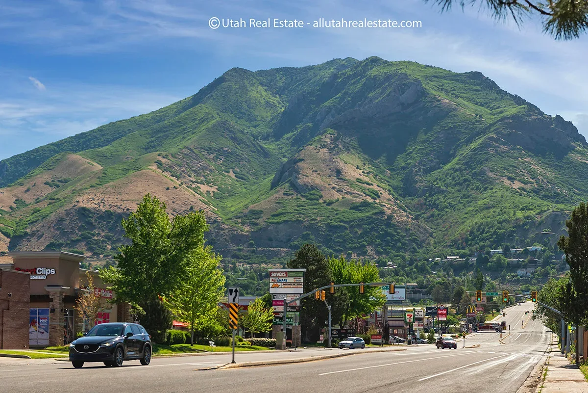 A Millcreek streetscape with the Wasatch Mountains rising behind the rooftops