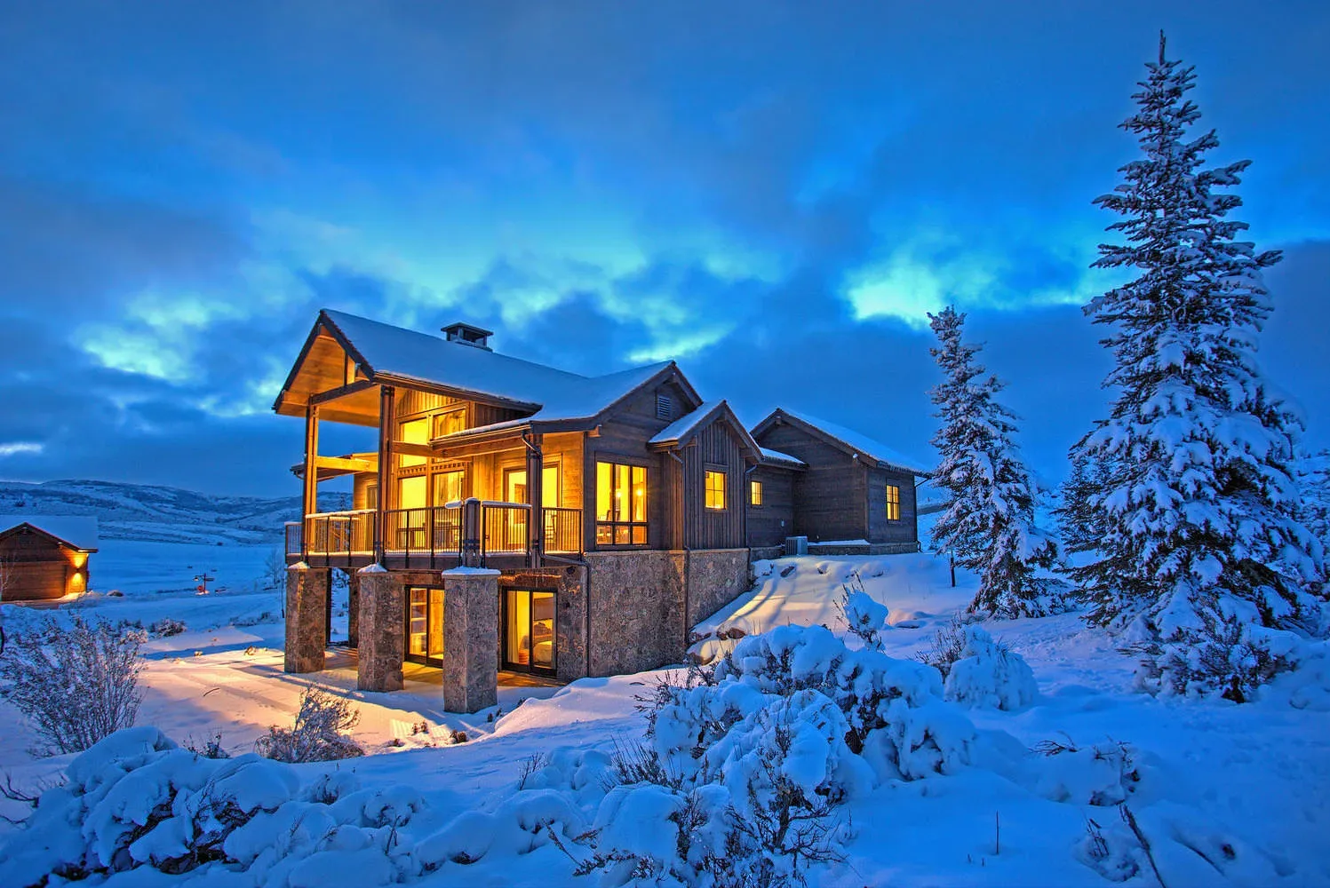 A mountain home glowing at twilight in the Victory Ranch preserve