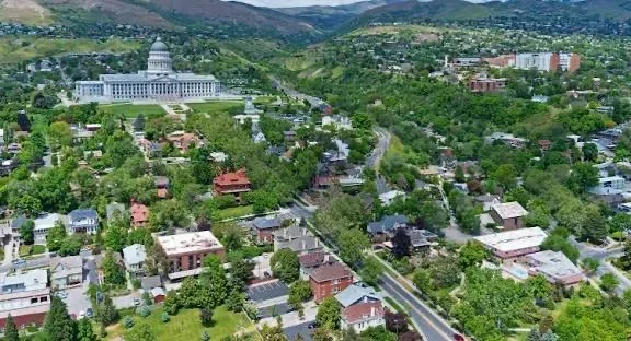 A drone view over Marmalade District rooftops with the Utah State Capitol dome rising above the trees