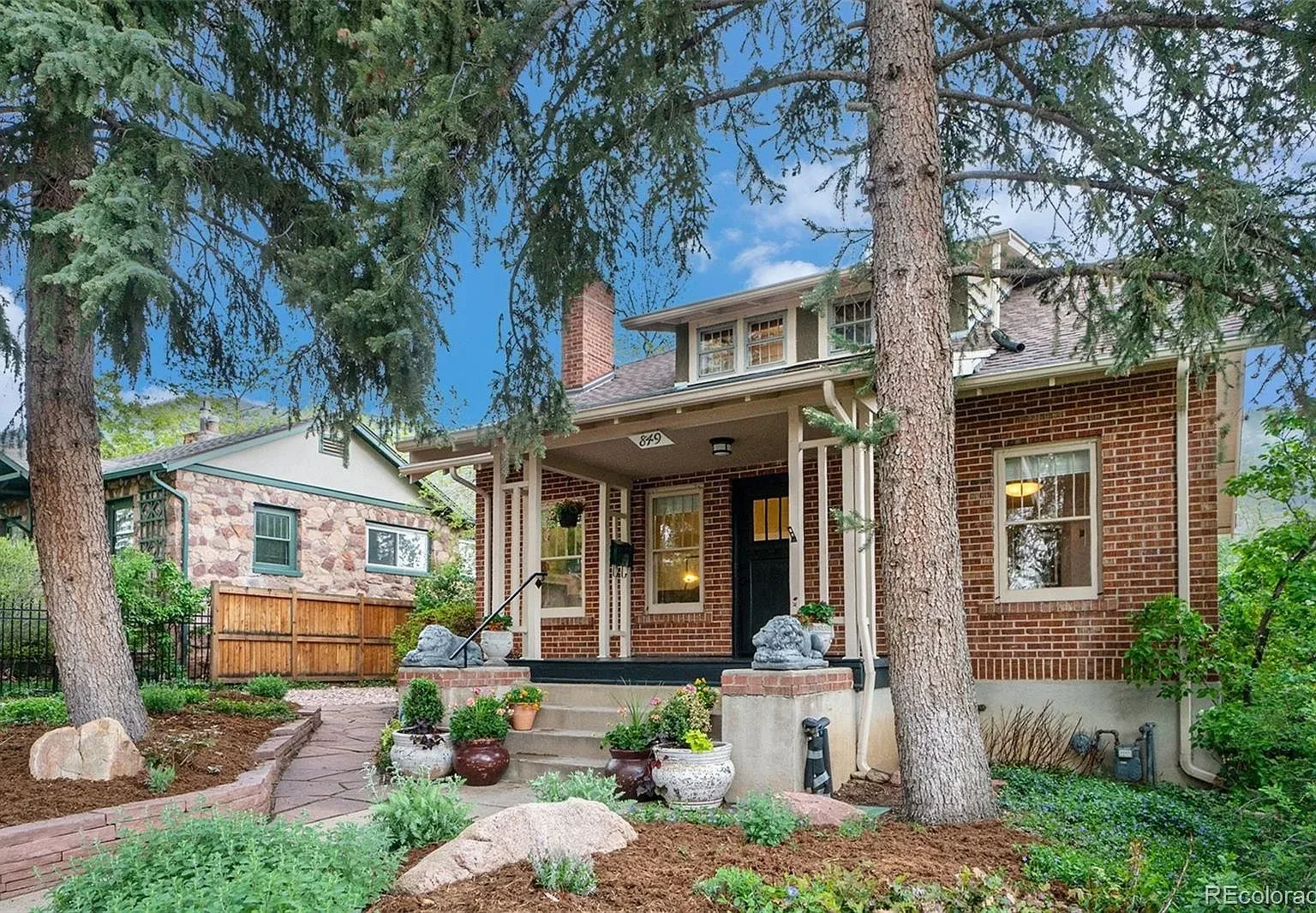 A brick craftsman home facade in 9th and 9th, the original early-1900s brickwork and porch under mature trees