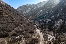 An aerial view of a winding canyon road climbing the Wasatch Mountains
