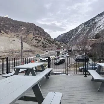 An elevated wooden deck overlooking a mountain town street with peaks in the distance
