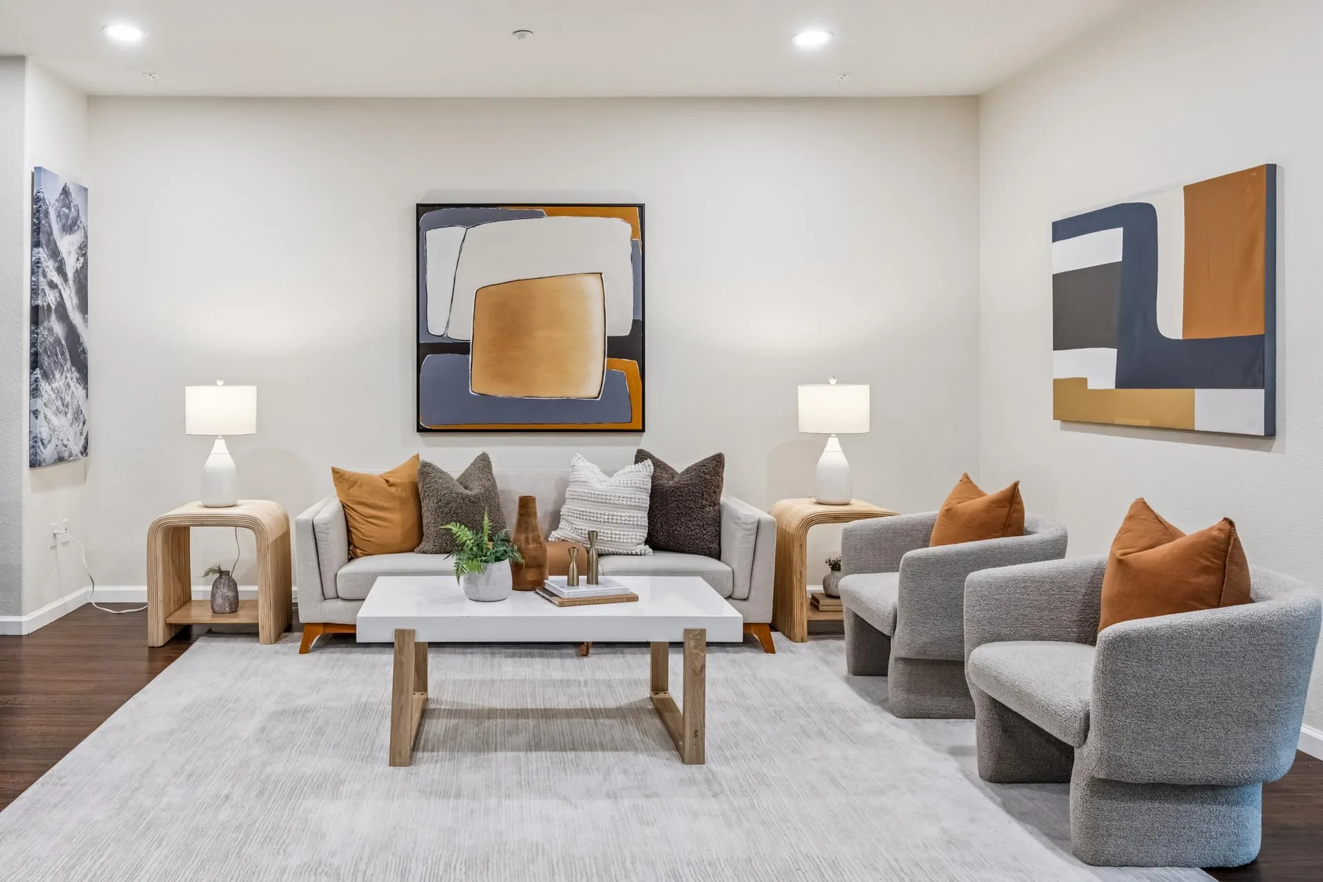 Living room seating area with sofa, armchairs and recessed ceiling lights