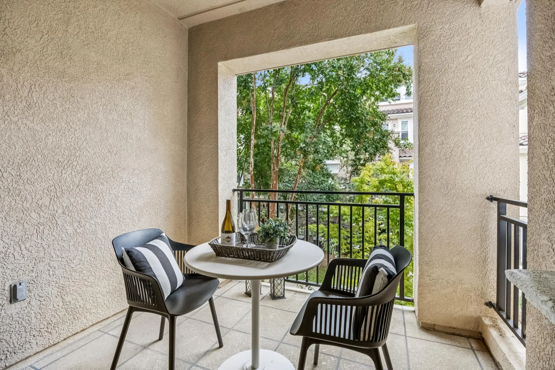 Private patio overlooking green common space with bistro table