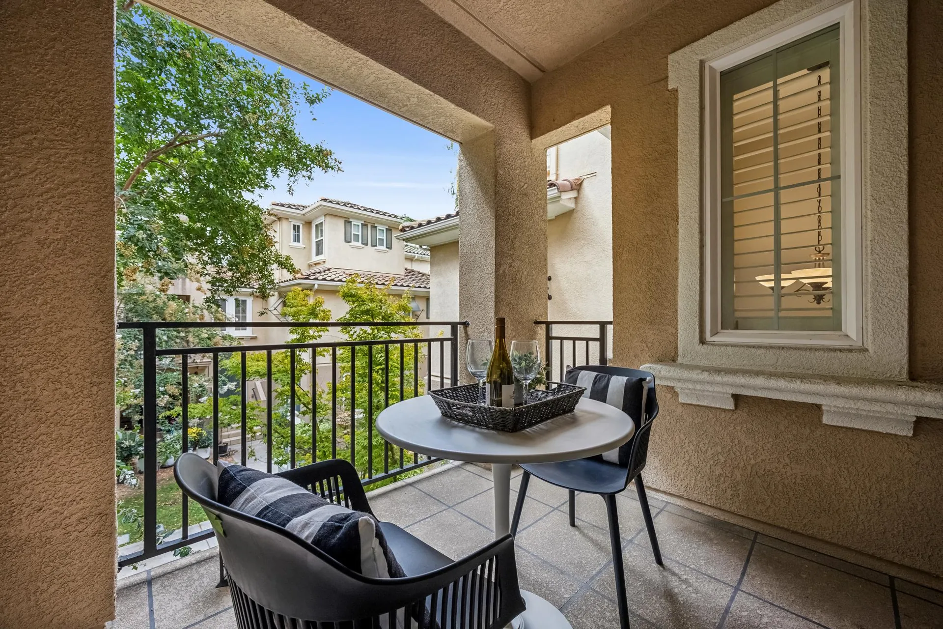 Covered patio with railing overlooking the landscaped common area