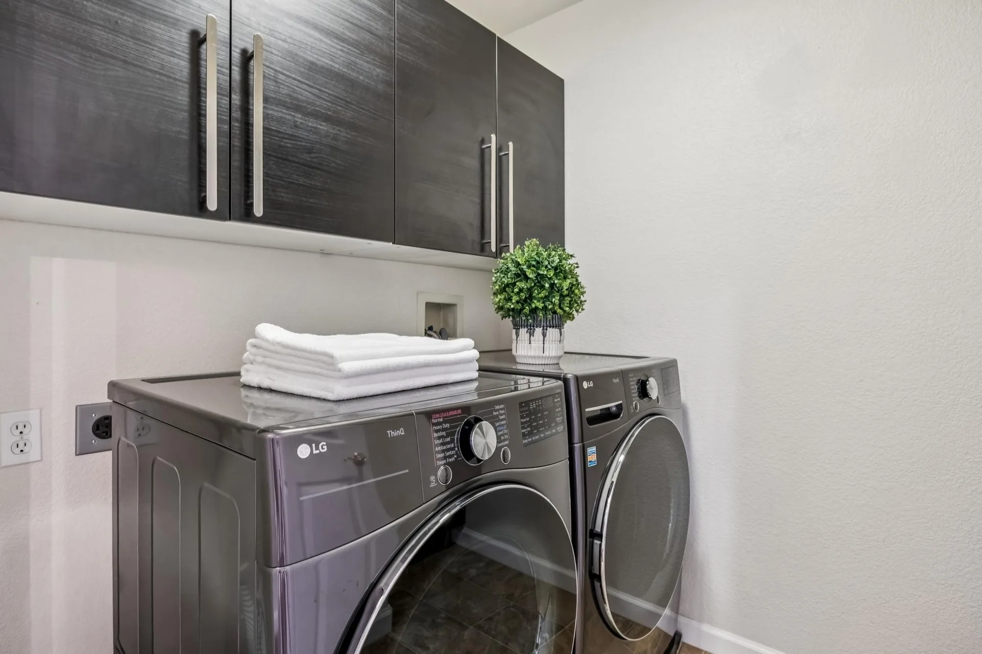 In-unit laundry with front-loading washer and dryer and upper cabinets