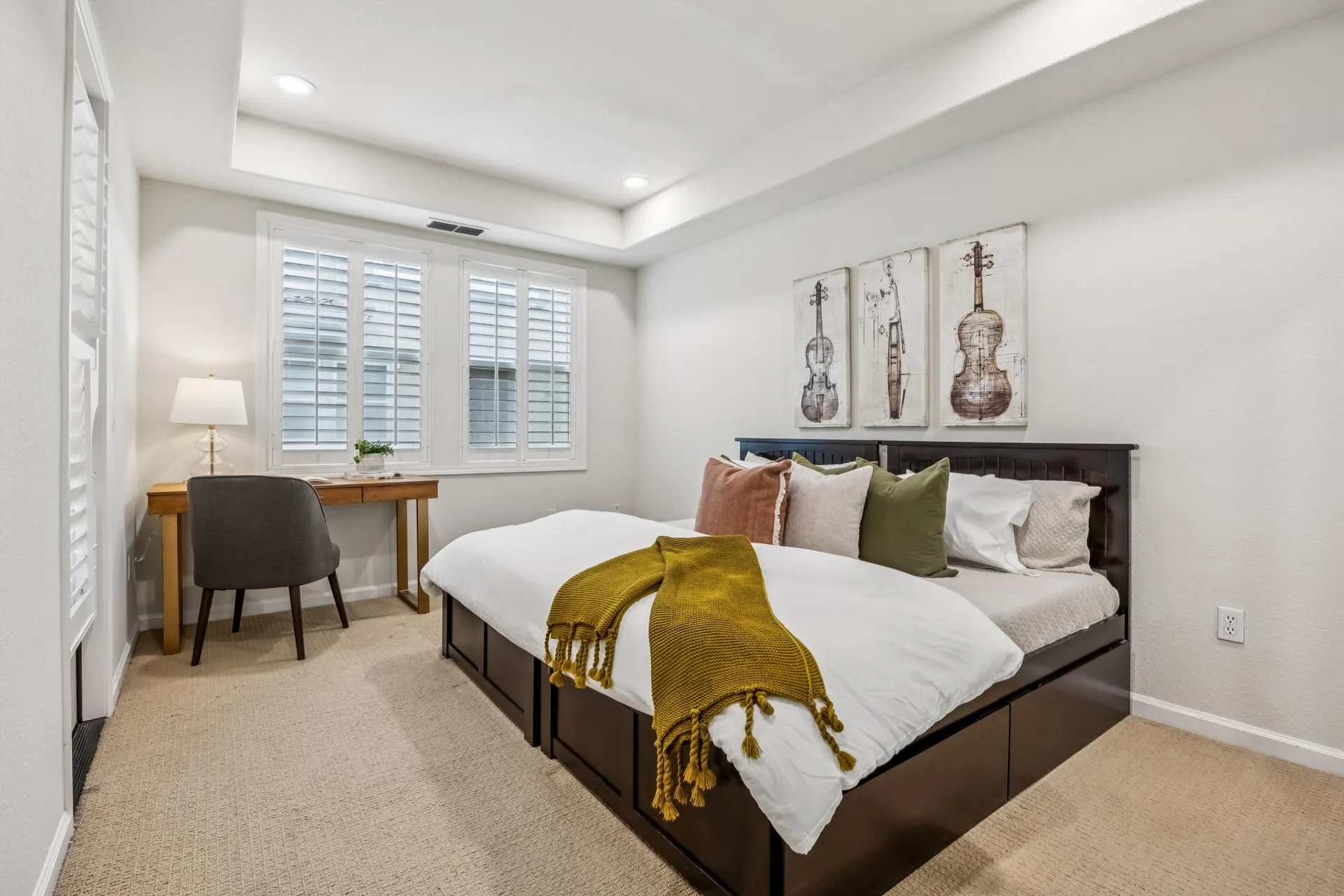 Primary bedroom with tray ceiling and writing desk near the window