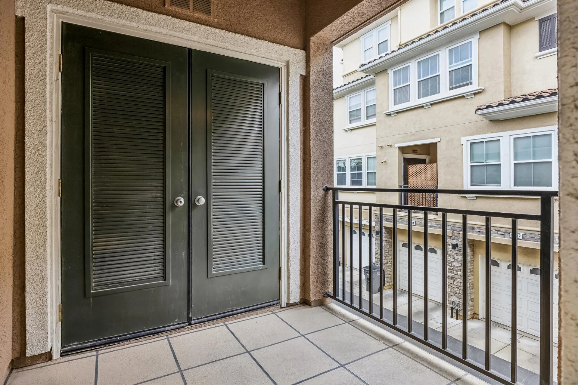 Upper terrace with double doors, tile flooring and metal railing