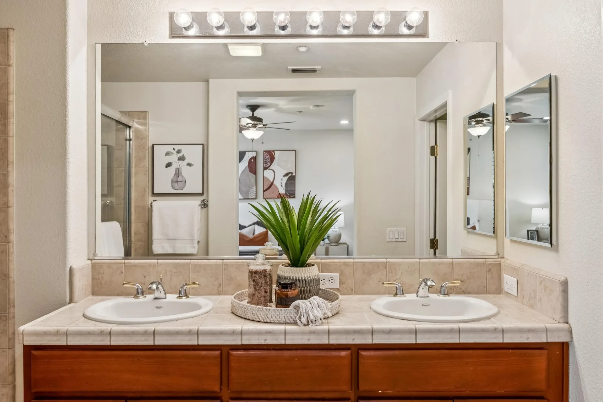 Bathroom with double vanity, tiled countertop and wall-to-wall mirror