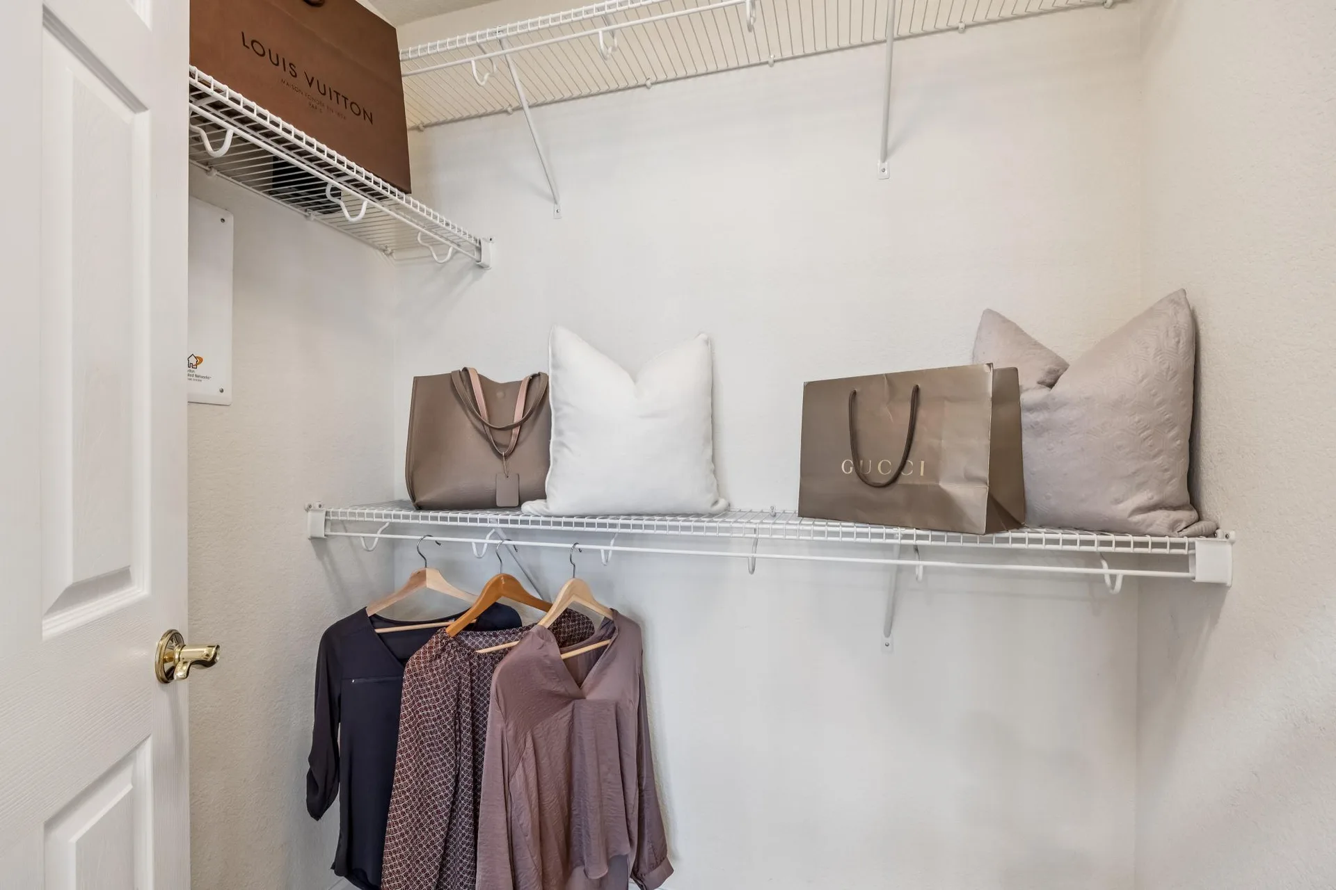 Walk-in closet with white wire shelving and hanging space
