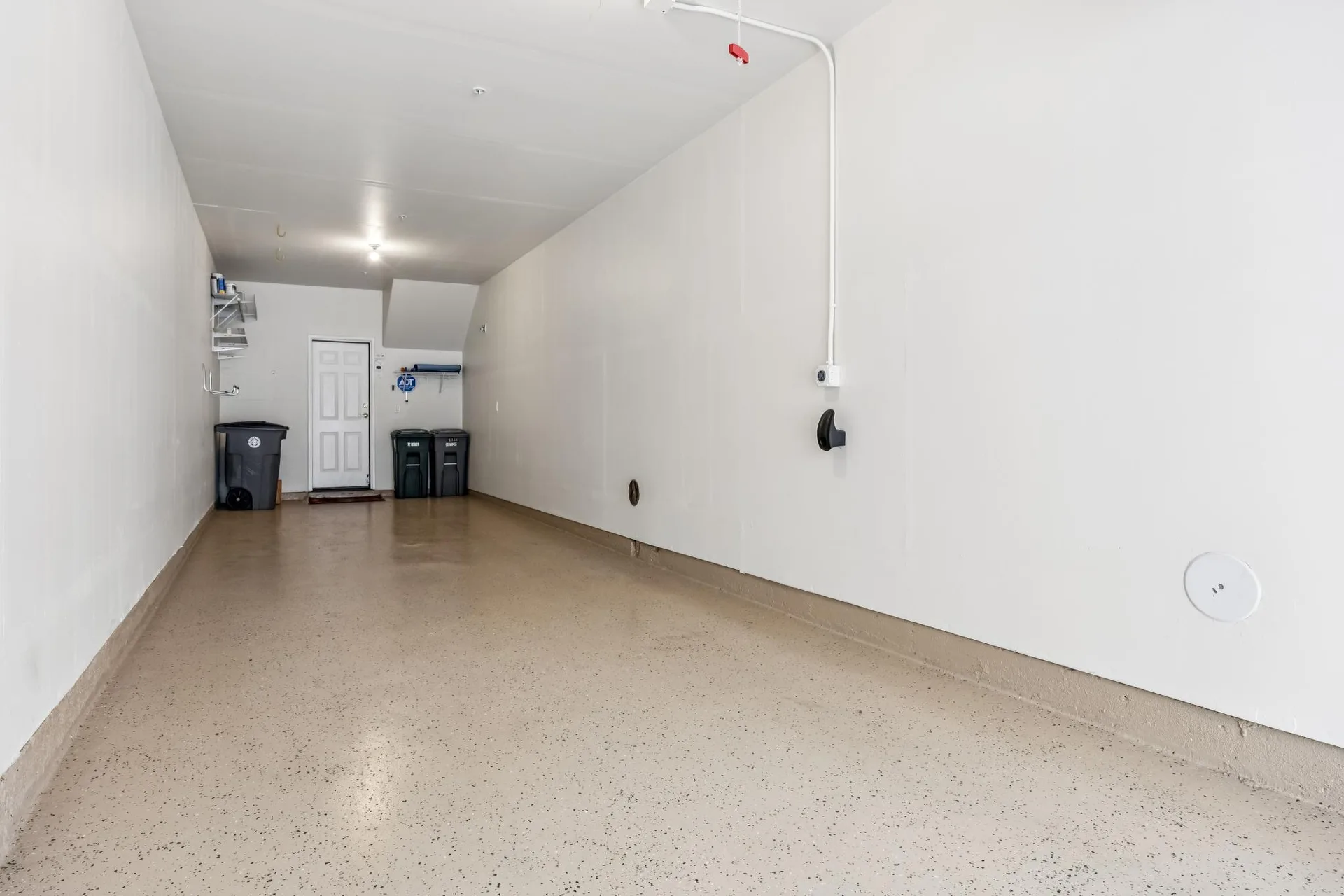 Garage interior with finished walls, epoxy floor and ceiling lighting