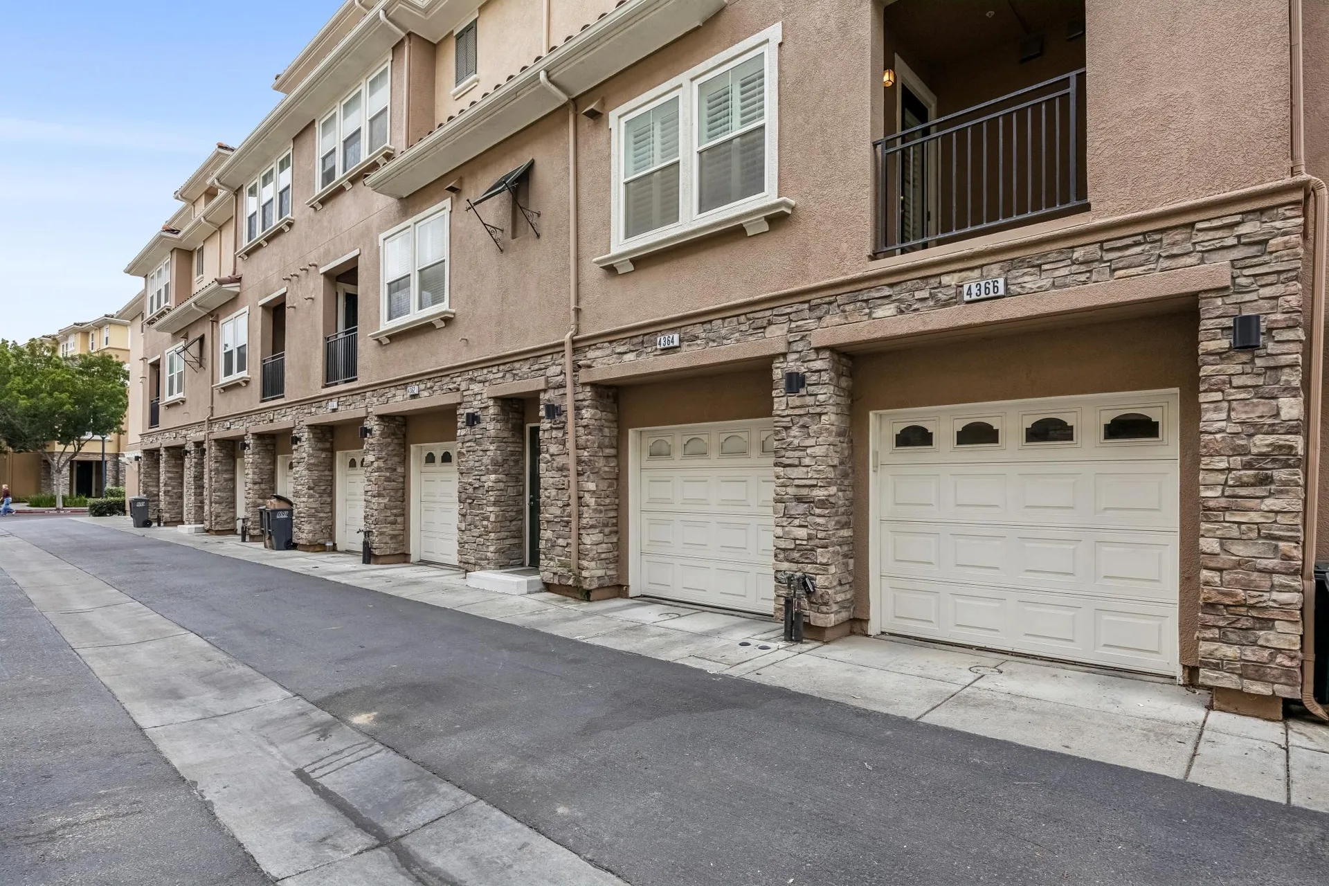 Exterior of the attached tandem garage with stucco and stone veneer facade