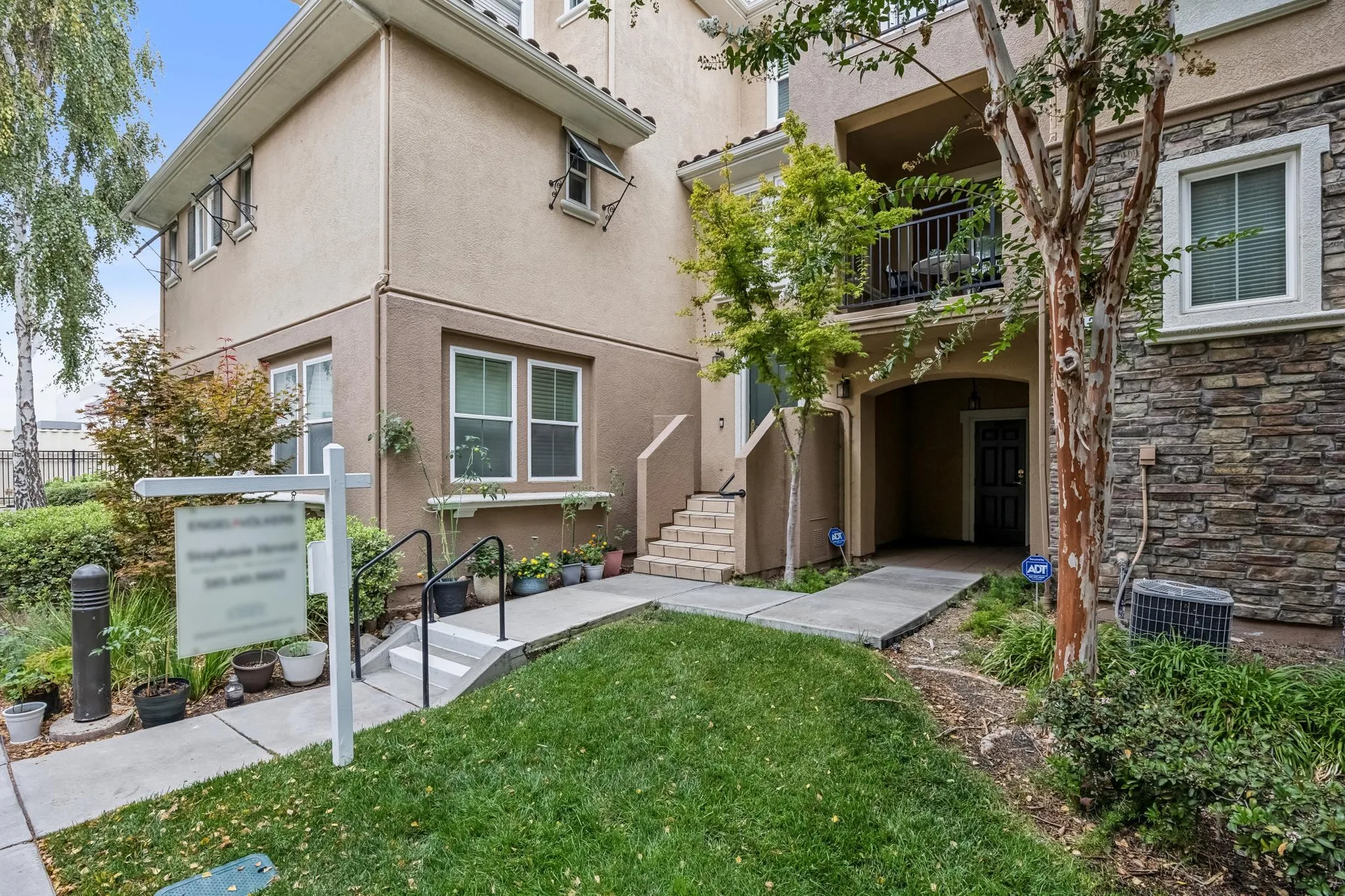 Townhome at 4366 Fitzwilliam St with stucco and stone veneer facade, front stairs and upper balcony