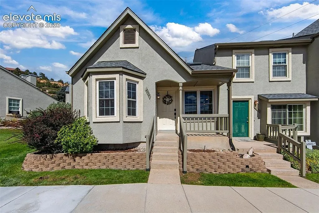 Front facade of the townhome with a front porch and landscaping