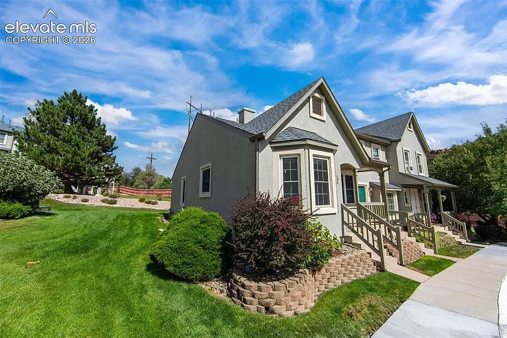 Side angle of the townhome with stone retaining wall and wooden railings