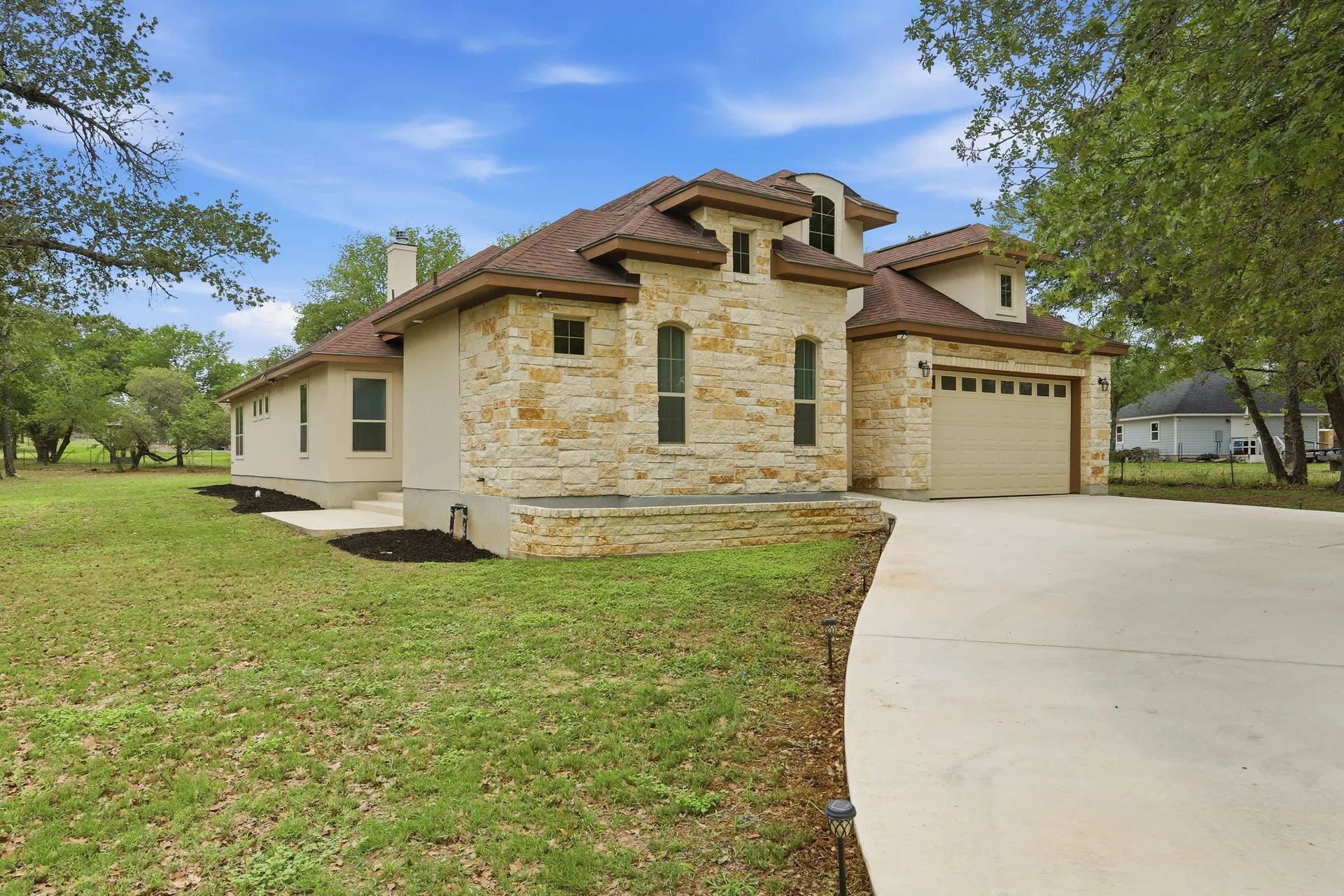 Front facade of the custom single-story home at 306 County Road 6876 in Natalia, Texas