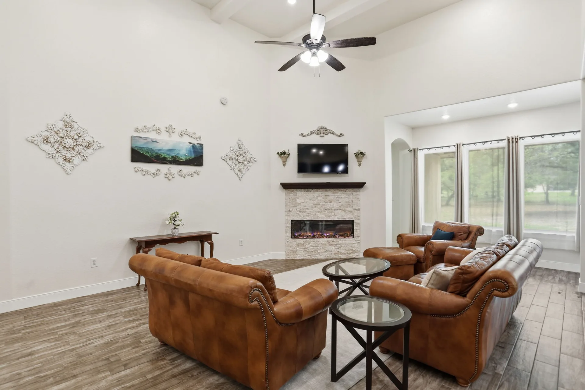 Open living room with stacked stone fireplace and 16-foot ceiling