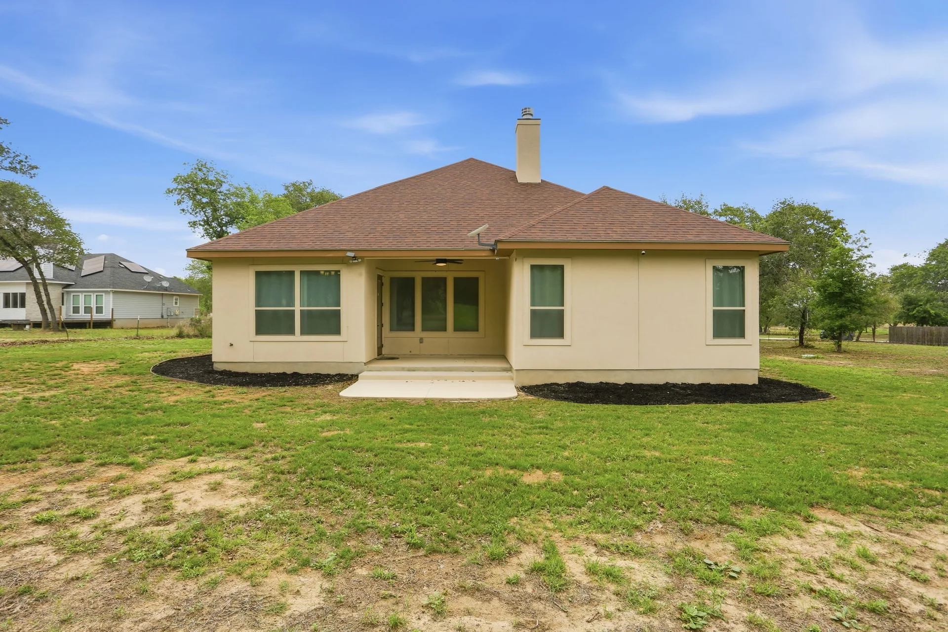 Covered patio and open lawn on the 1.83-acre lot at 306 County Road 6876