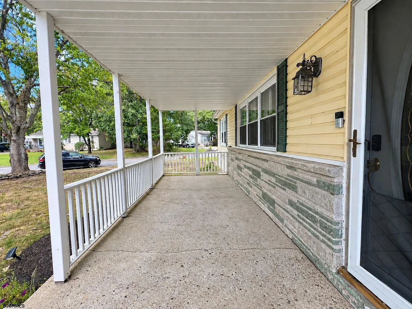 Covered front porch with white columns and railing